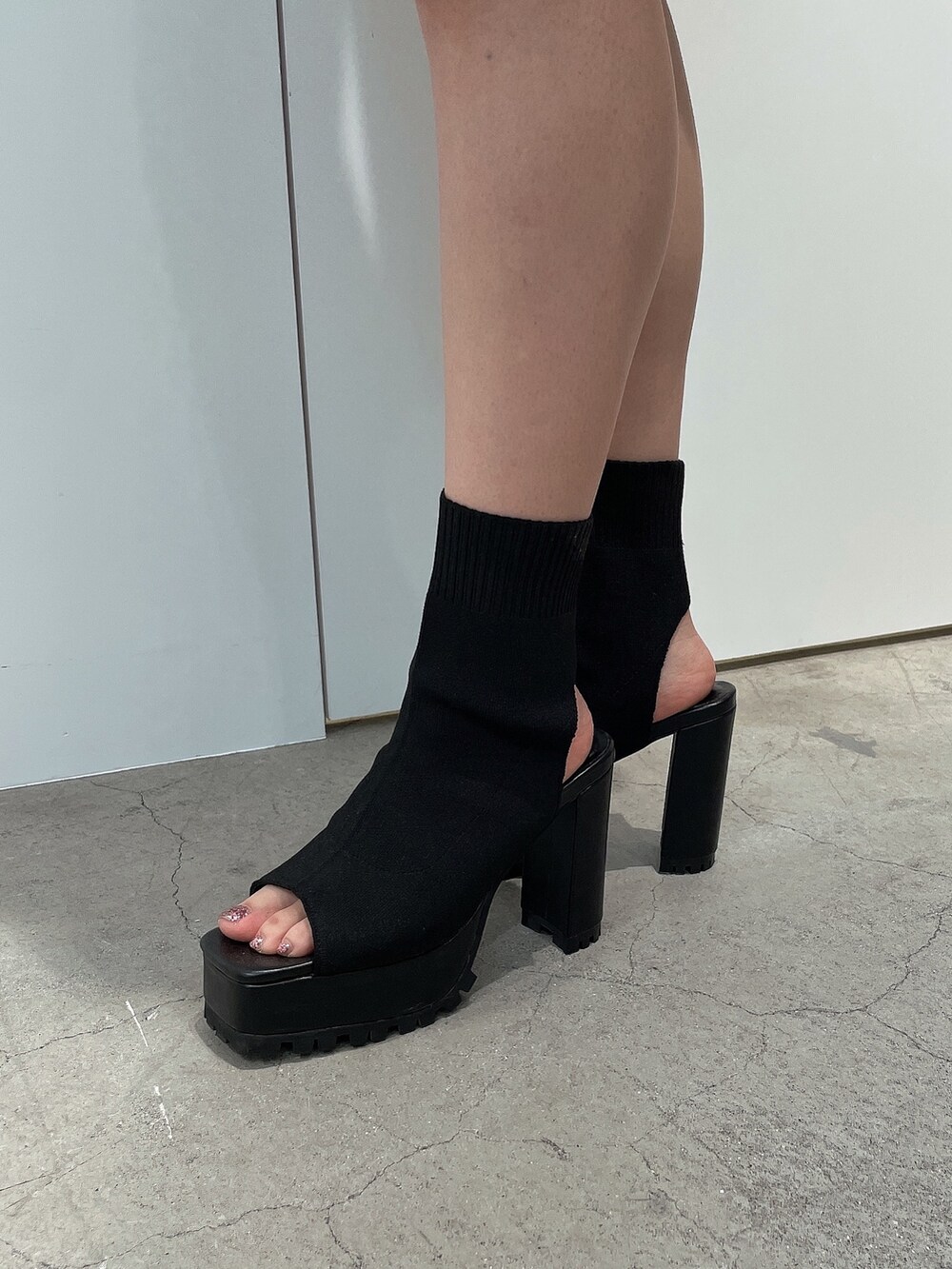 ホワイト系のワンピース、ブラック系のブーツを着用したレディースの夏コーディネートの7枚目の写真