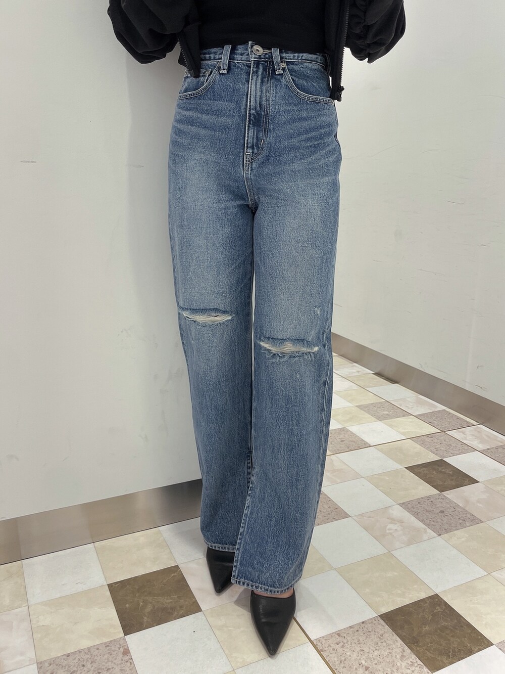 ブラック系のパーカー、ブルー系のデニムパンツ、ブラック系のパンプスを着用したレディースの冬コーディネートの7枚目の写真