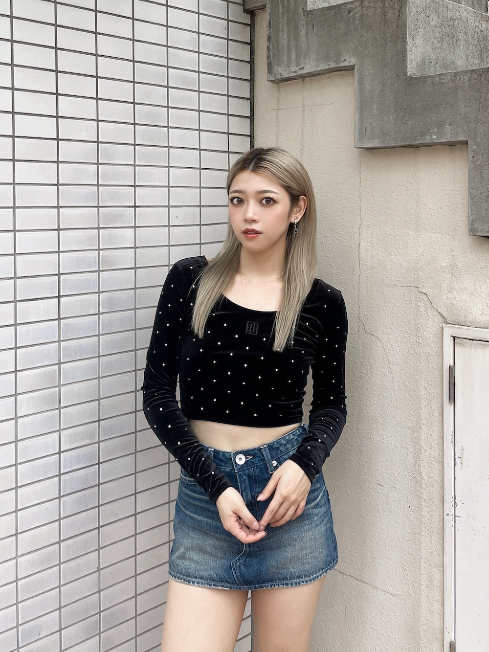 ブラック系のTシャツ/カットソー、ブルー系のデニムスカート、ブラック系のブーツを着用したレディースの秋コーディネートの3枚目の写真