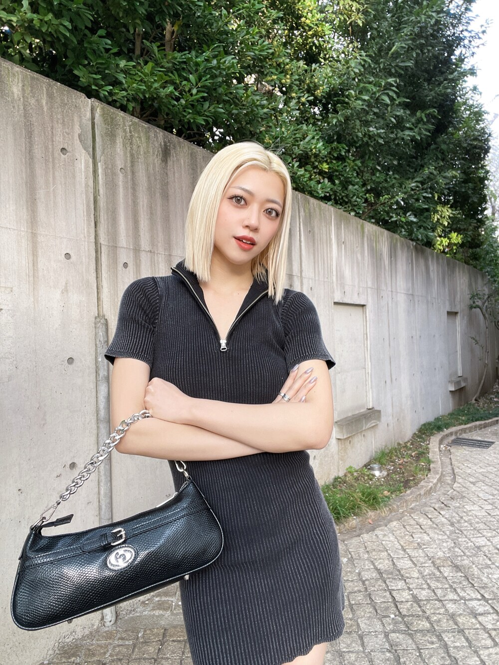 ブラック系のワンピース、ブラック系のサンダル、ブラック系のハンドバッグを着用したレディースの春コーディネートの4枚目の写真