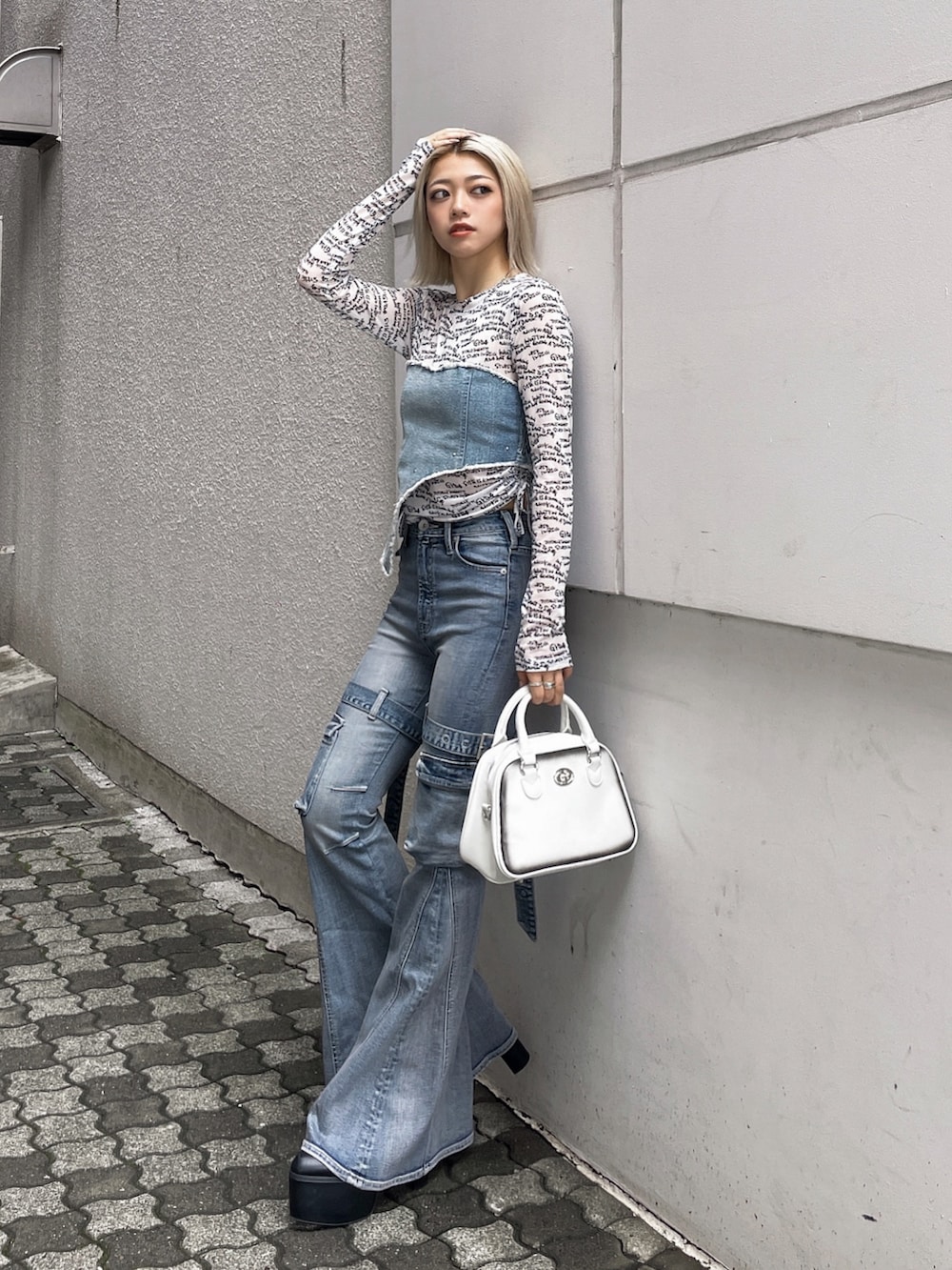 ホワイト系のTシャツ/カットソー、ブルー系のデニムパンツ、ブラック系のブーツを着用したレディースの夏コーディネートの2枚目の写真