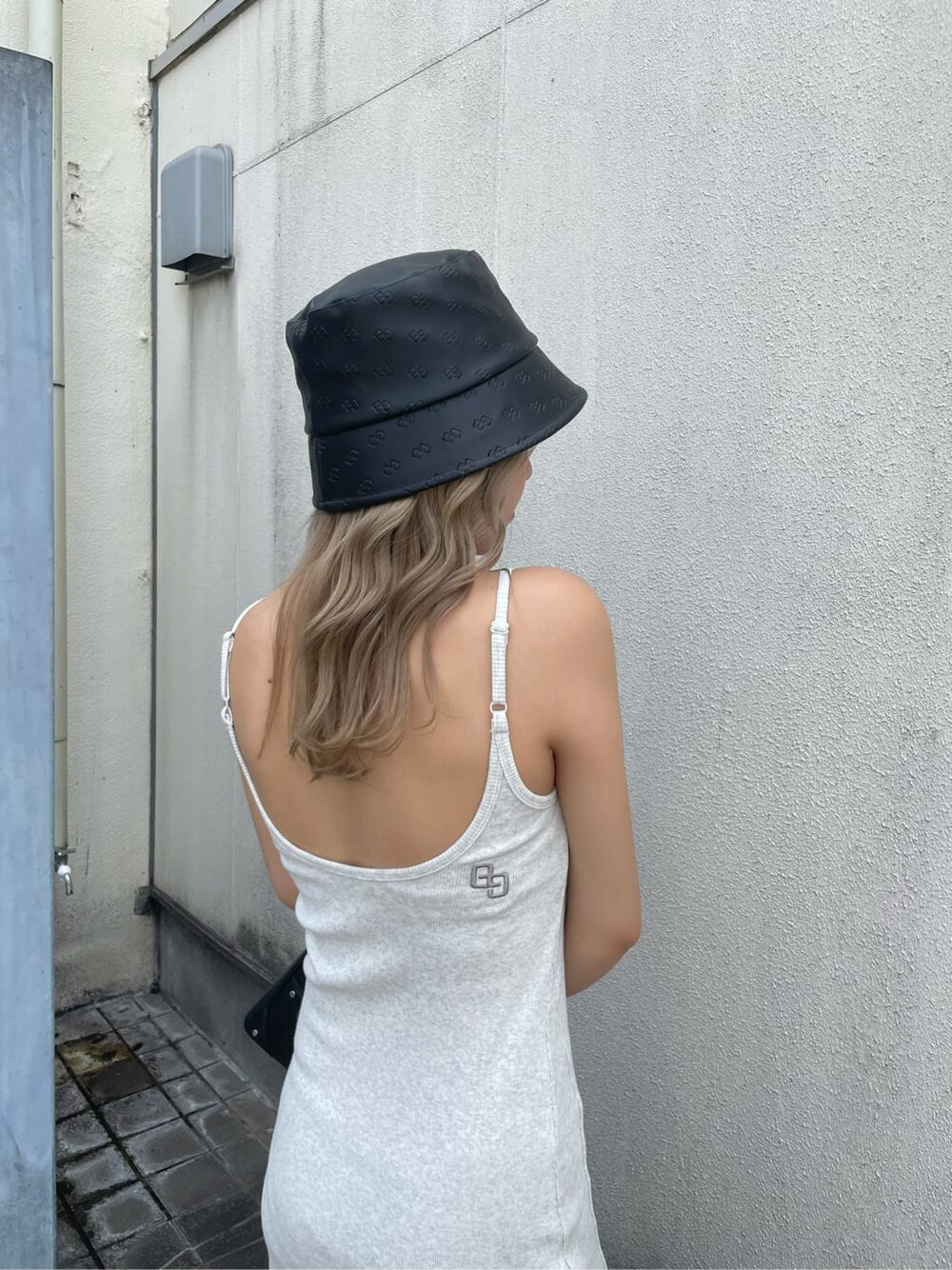 グレー系のワンピース、ブラック系のハットを着用したレディースの夏コーディネートの5枚目の写真