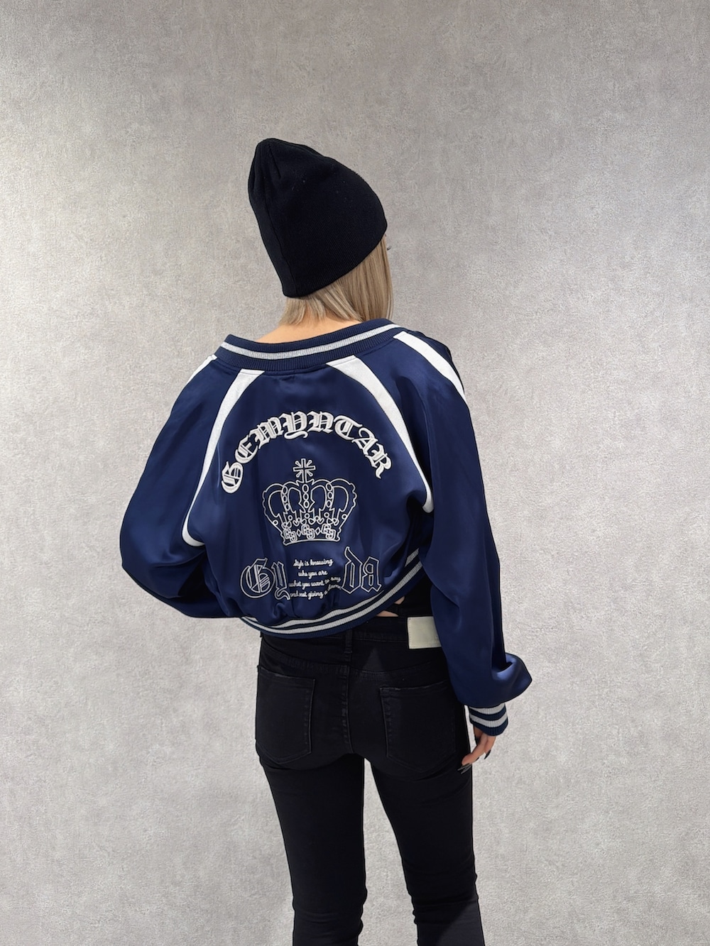 ブルー系のブルゾン、ブラック系のデニムパンツ、ブラック系のブーツを着用したレディースの春コーディネートの3枚目の写真