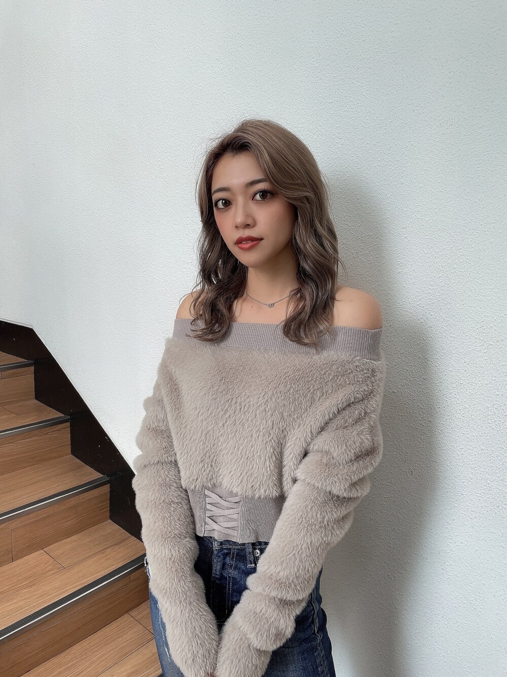 ベージュ系のニット/セーター、ブルー系のデニムパンツ、ブラック系のパンプスを着用したレディースの秋コーディネートの2枚目の写真