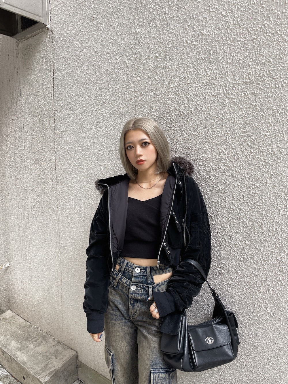 ブラック系のブルゾン、ブラック系のデニムパンツ、ブラック系のブーツを着用したレディースの秋コーディネートの3枚目の写真