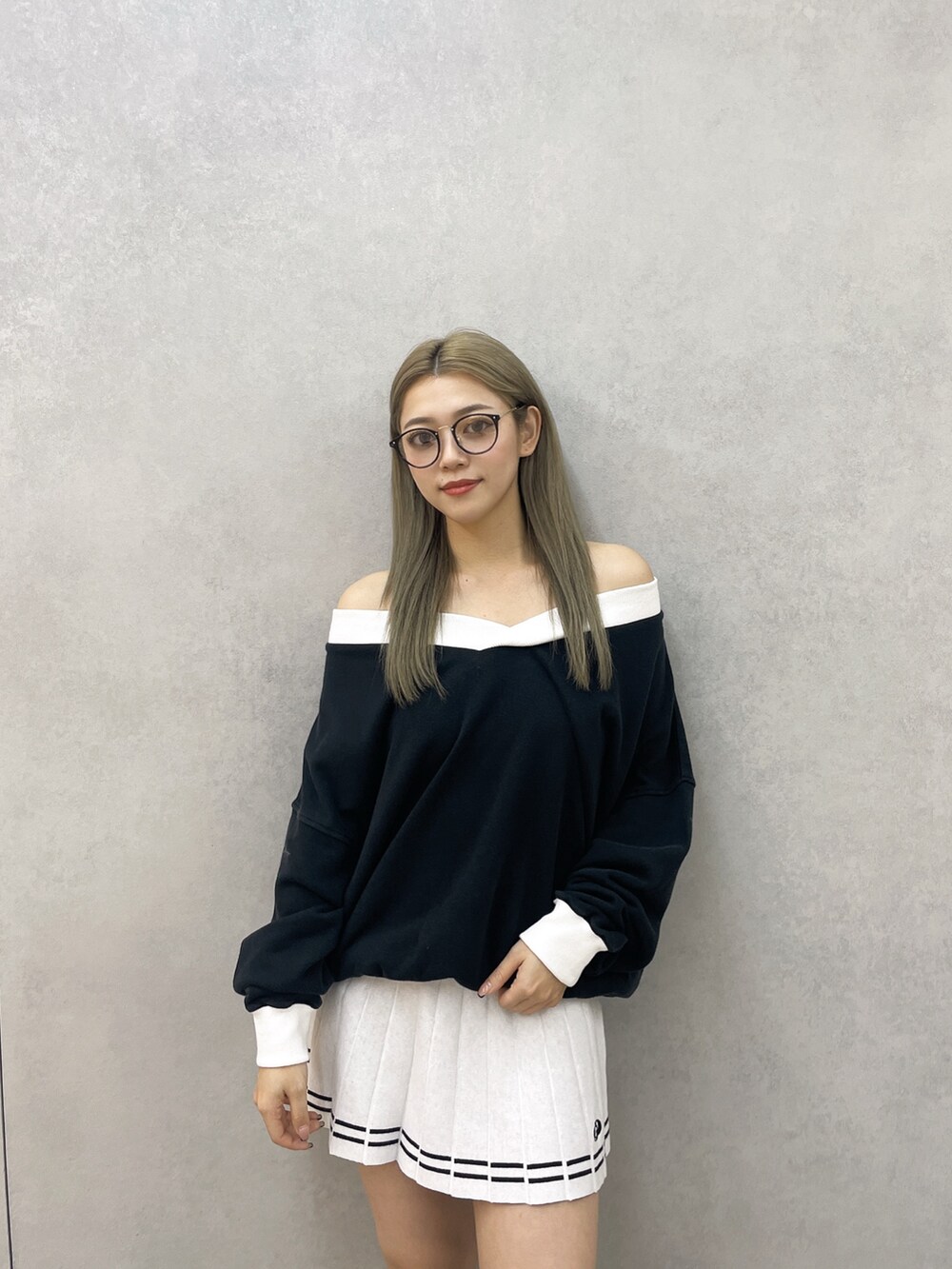 ブラック系のスウェット、ホワイト系のスカート、ブラック系のブーツを着用したレディースの冬コーディネートの3枚目の写真