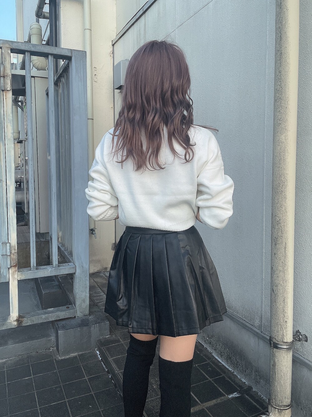 ホワイト系のニット/セーター、ブラック系のスカート、ブラック系のブーツを着用したレディースの秋コーディネートの5枚目の写真