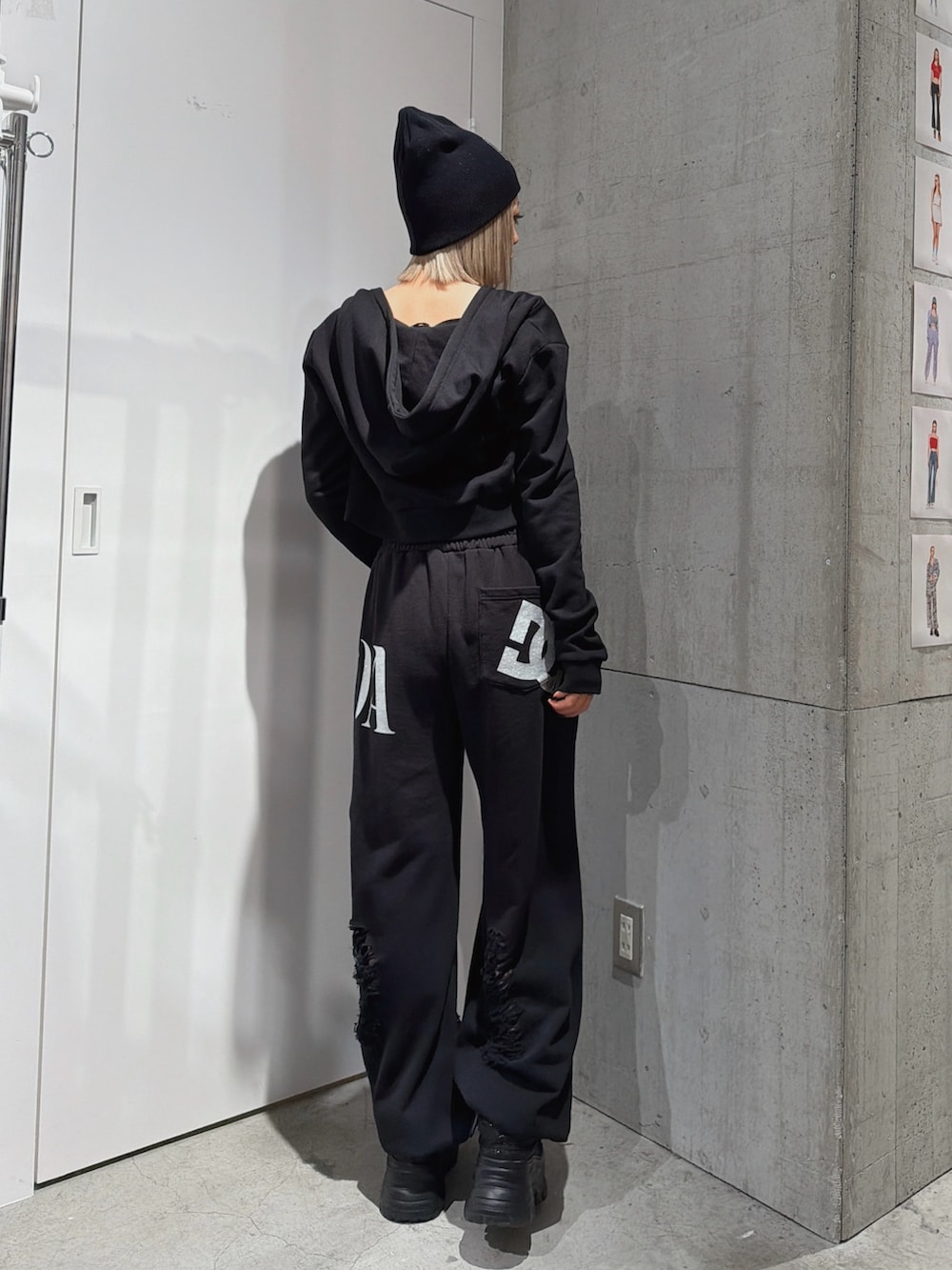 ブラック系のスウェットパンツ、ブラック系のパーカー、ブルー系のキャミソールを着用したレディースの春コーディネートの2枚目の写真