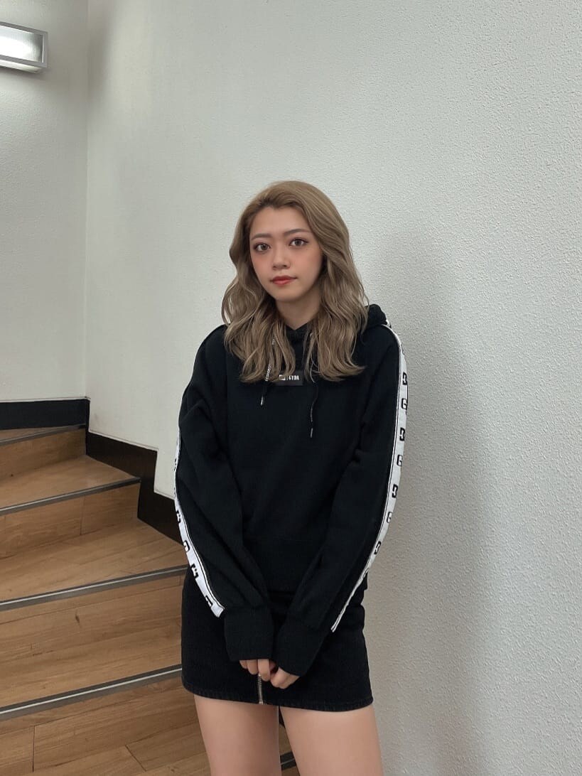 ブラック系のデニムスカート、ブラック系のブーツ、ブラック系のTシャツ/カットソーを着用したレディースの秋コーディネートの4枚目の写真