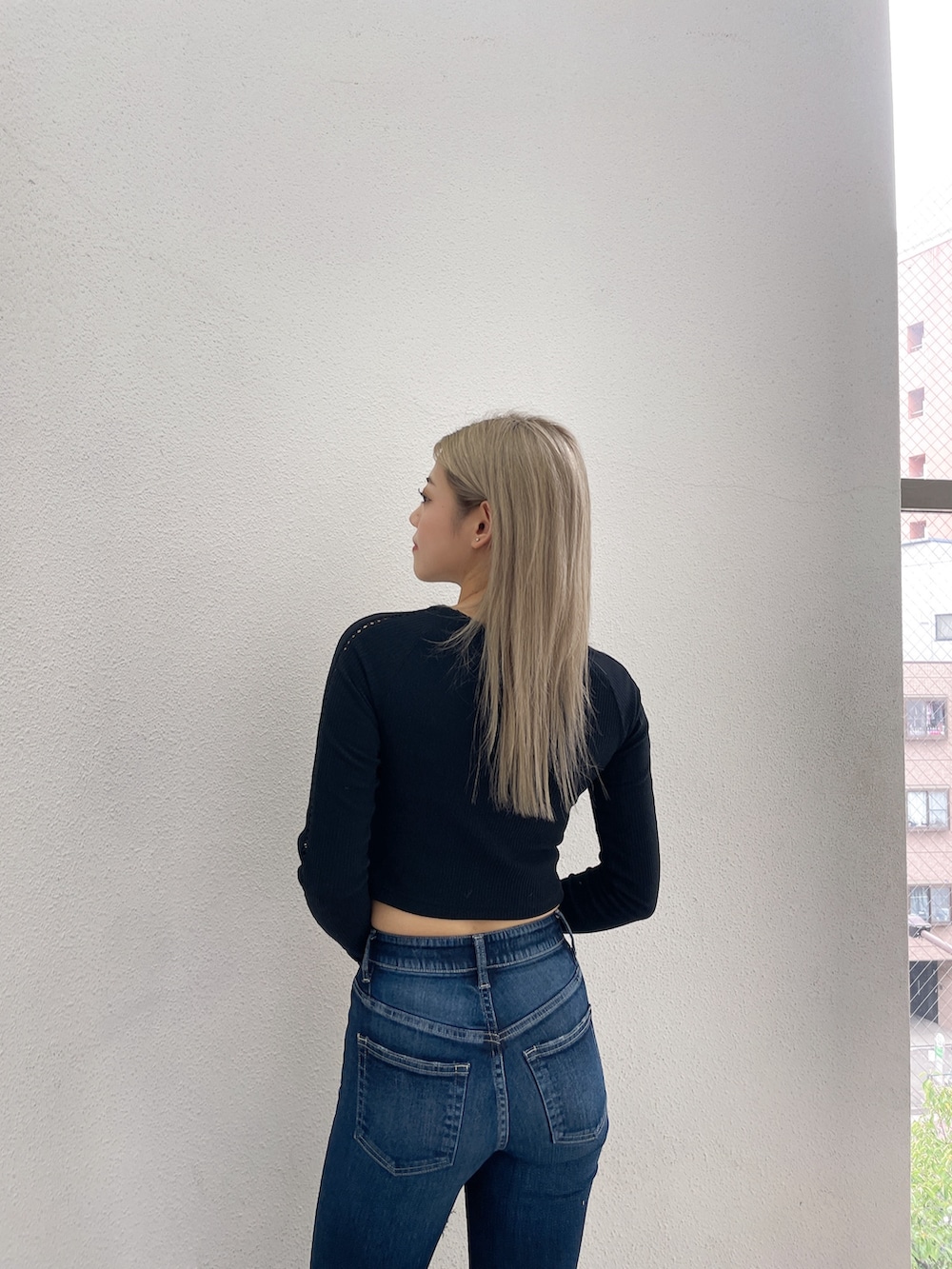 ブラック系のTシャツ/カットソー、ブルー系のデニムパンツ、ブラック系のブーツを着用したレディースの秋コーディネートの5枚目の写真