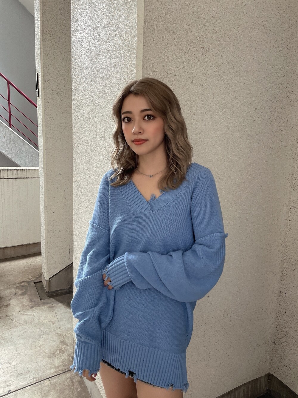 ブルー系のニット/セーター、ブラック系のブーツを着用したレディースの秋コーディネートの4枚目の写真