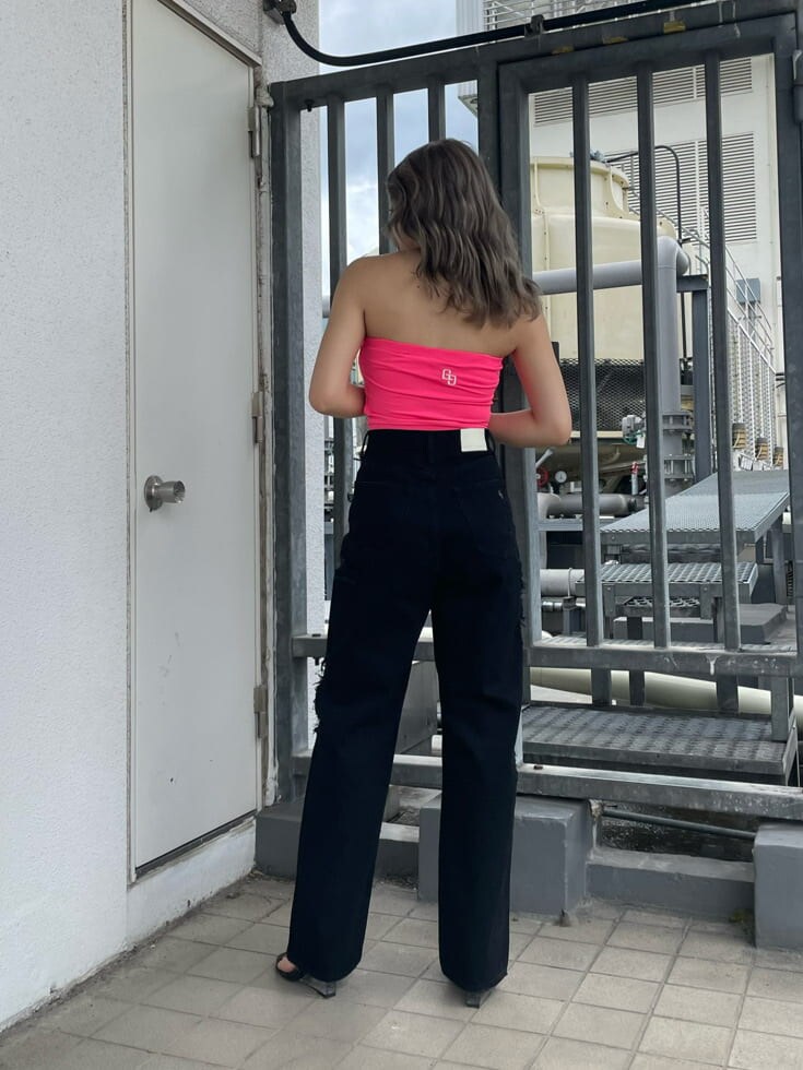 ブラック系のサンダル、ブラック系のデニムパンツ、ピンク系のチューブトップを着用したレディースの夏コーディネートの4枚目の写真