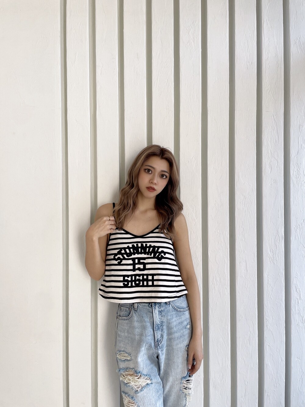 その他のキャミソール、ブルー系のデニムパンツ、ブラック系のパンプスを着用したレディースの春コーディネートの4枚目の写真