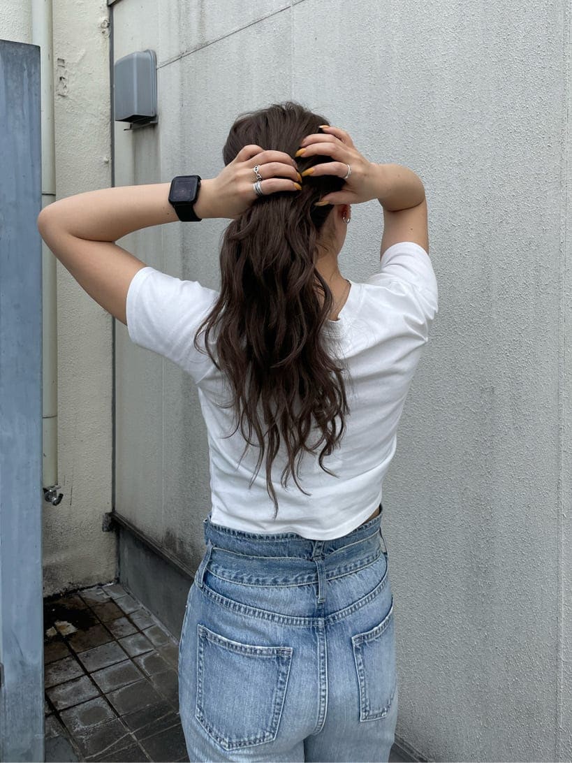 ホワイト系のサンダル、ホワイト系のTシャツ/カットソー、ブルー系のデニムパンツを着用したレディースの春コーディネートの4枚目の写真