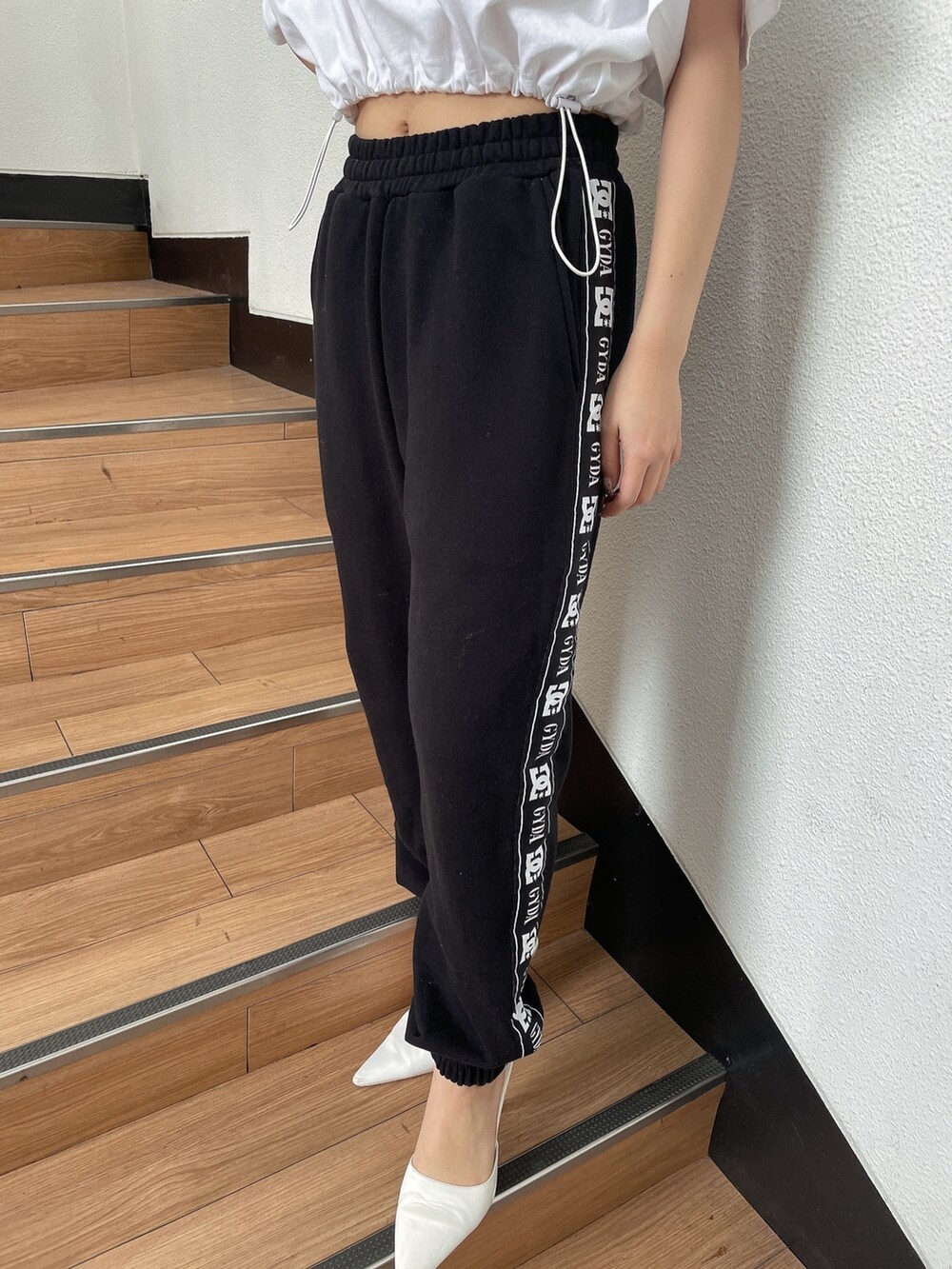 ホワイト系のTシャツ/カットソー、ブラック系のスウェットパンツ、ホワイト系のパンプスを着用したレディースの春コーディネートの7枚目の写真