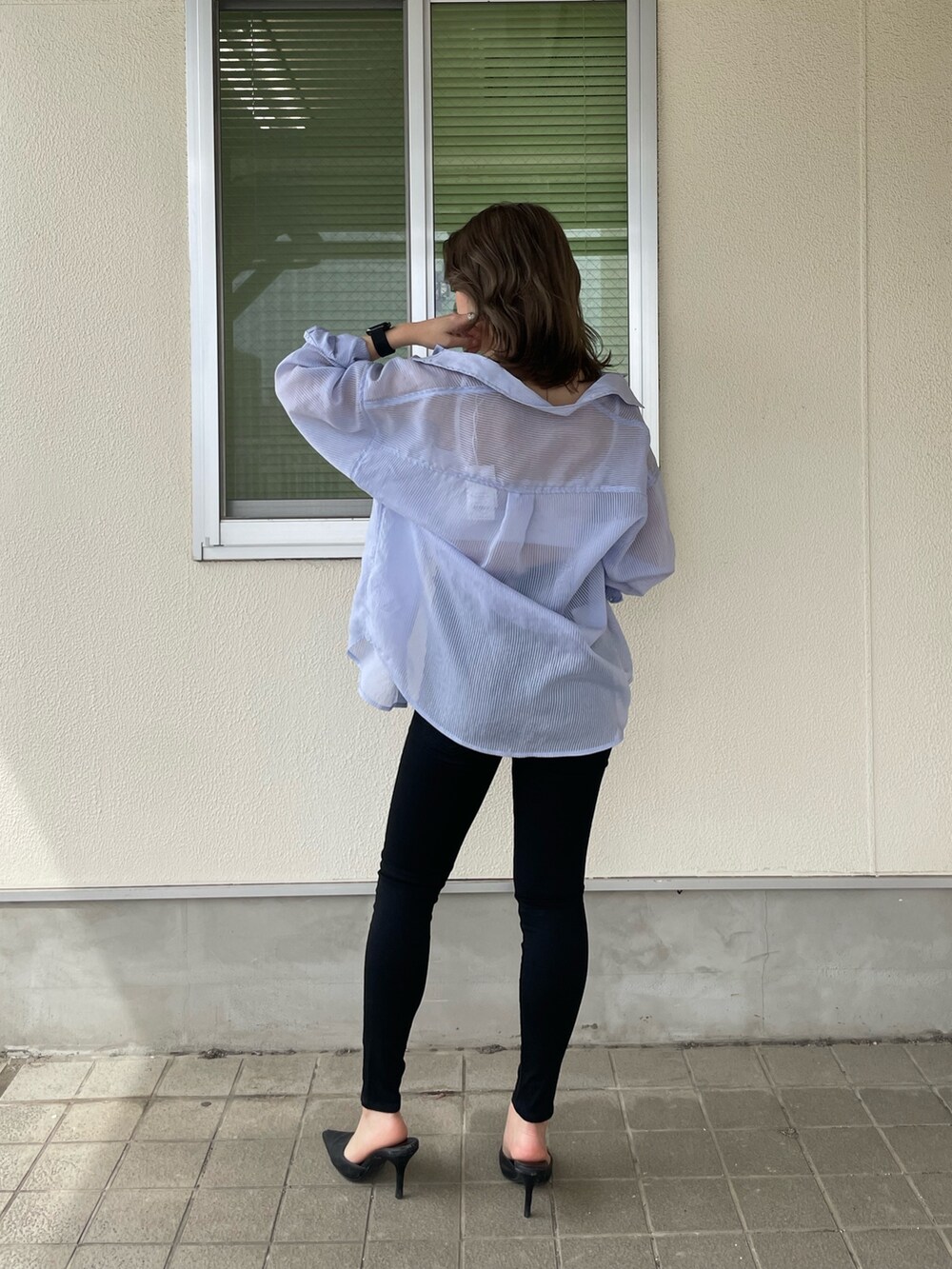 ブルー系のシャツ/ブラウス、ブラック系のデニムパンツ、ブラック系のパンプスを着用したレディースの春コーディネートの2枚目の写真