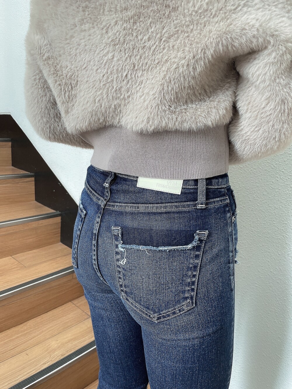 ベージュ系のニット/セーター、ブルー系のデニムパンツ、ブラック系のパンプスを着用したレディースの秋コーディネートの5枚目の写真