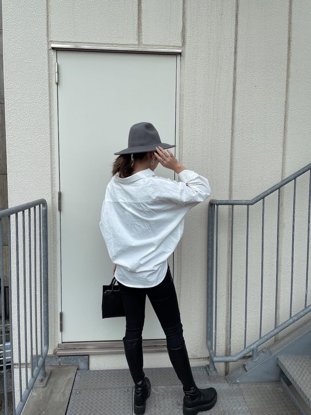ブラック系のハンドバッグ、ブラック系のデニムパンツ、ホワイト系のシャツ/ブラウスを着用したレディースの秋コーディネートの4枚目の写真