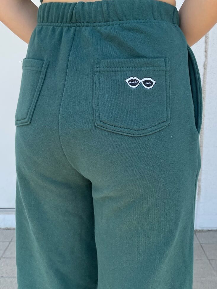 ブラック系のパンプス、ホワイト系のシャツ/ブラウス、グリーン系のスウェットパンツを着用したレディースの春コーディネートの6枚目の写真
