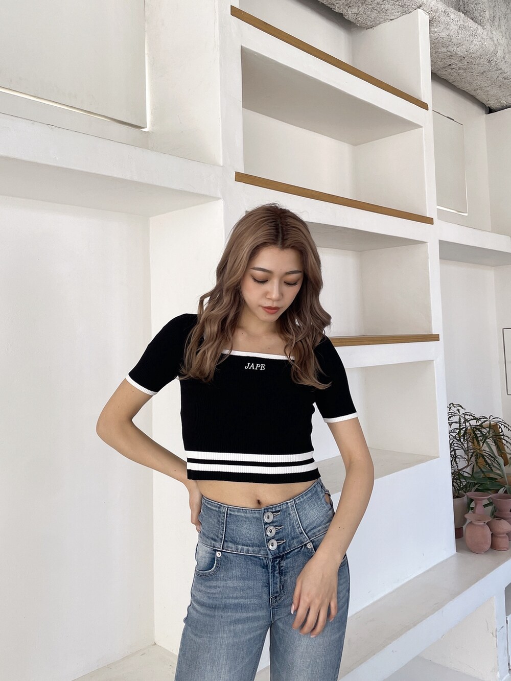 ブラック系のサンダル、ブルー系のデニムパンツ、ブラック系のニット/セーターを着用したレディースの春コーディネートの5枚目の写真