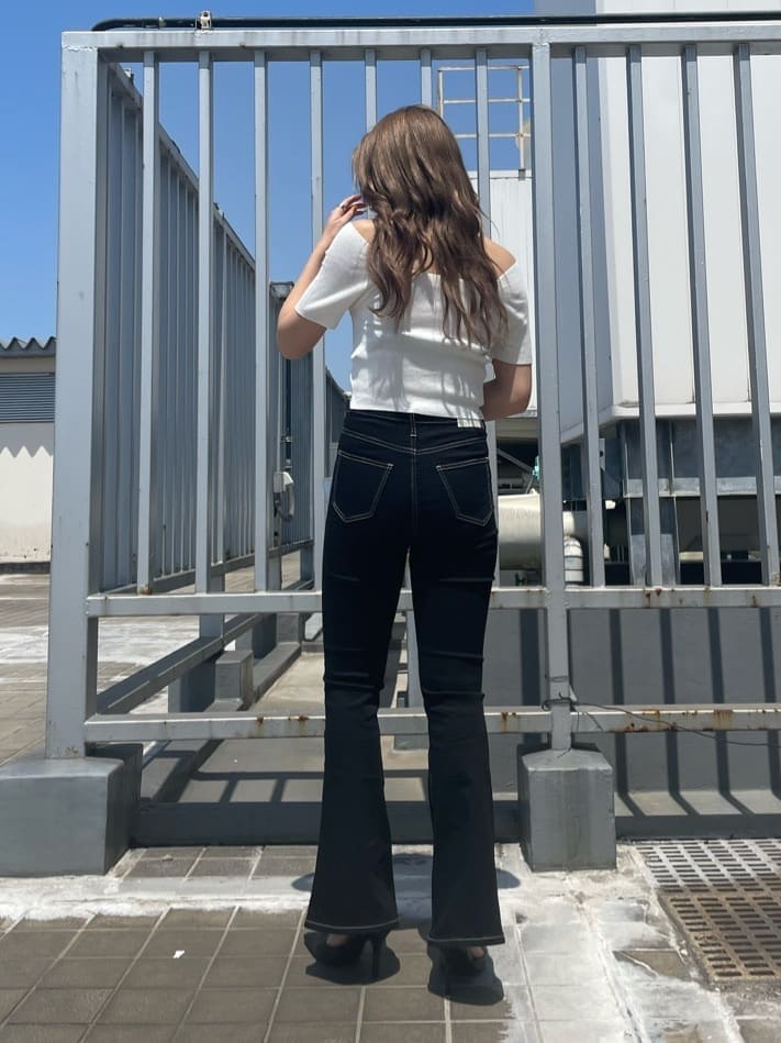 ブラック系のパンプス、ホワイト系のハンドバッグ、ホワイト系のニット/セーターを着用したレディースの春コーディネートの4枚目の写真