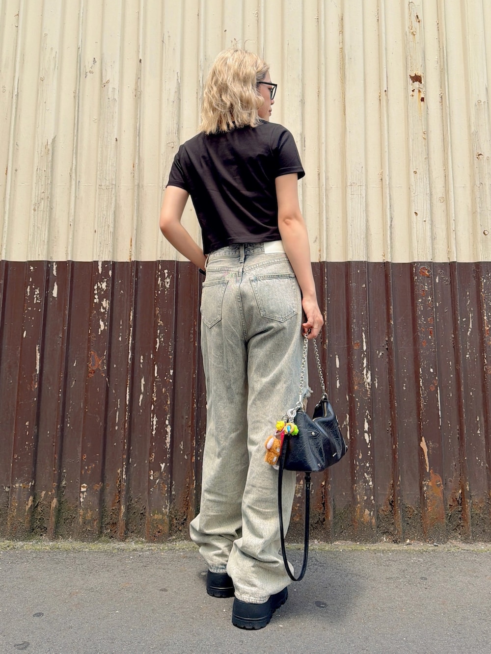 ブラック系のTシャツ/カットソー、ブラック系のスニーカー、ブルー系のつなぎ/オールインワンを着用したレディースの夏コーディネートの2枚目の写真