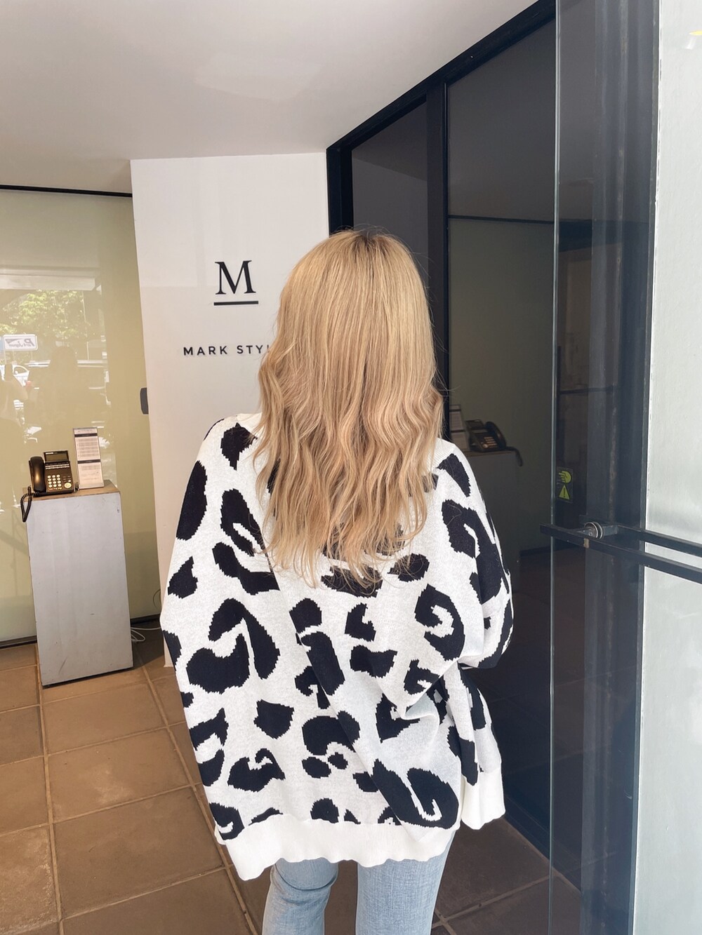 ホワイト系のカーディガン/ボレロ、ブルー系のデニムパンツ、ブラック系のパンプスを着用したレディースの夏コーディネートの5枚目の写真