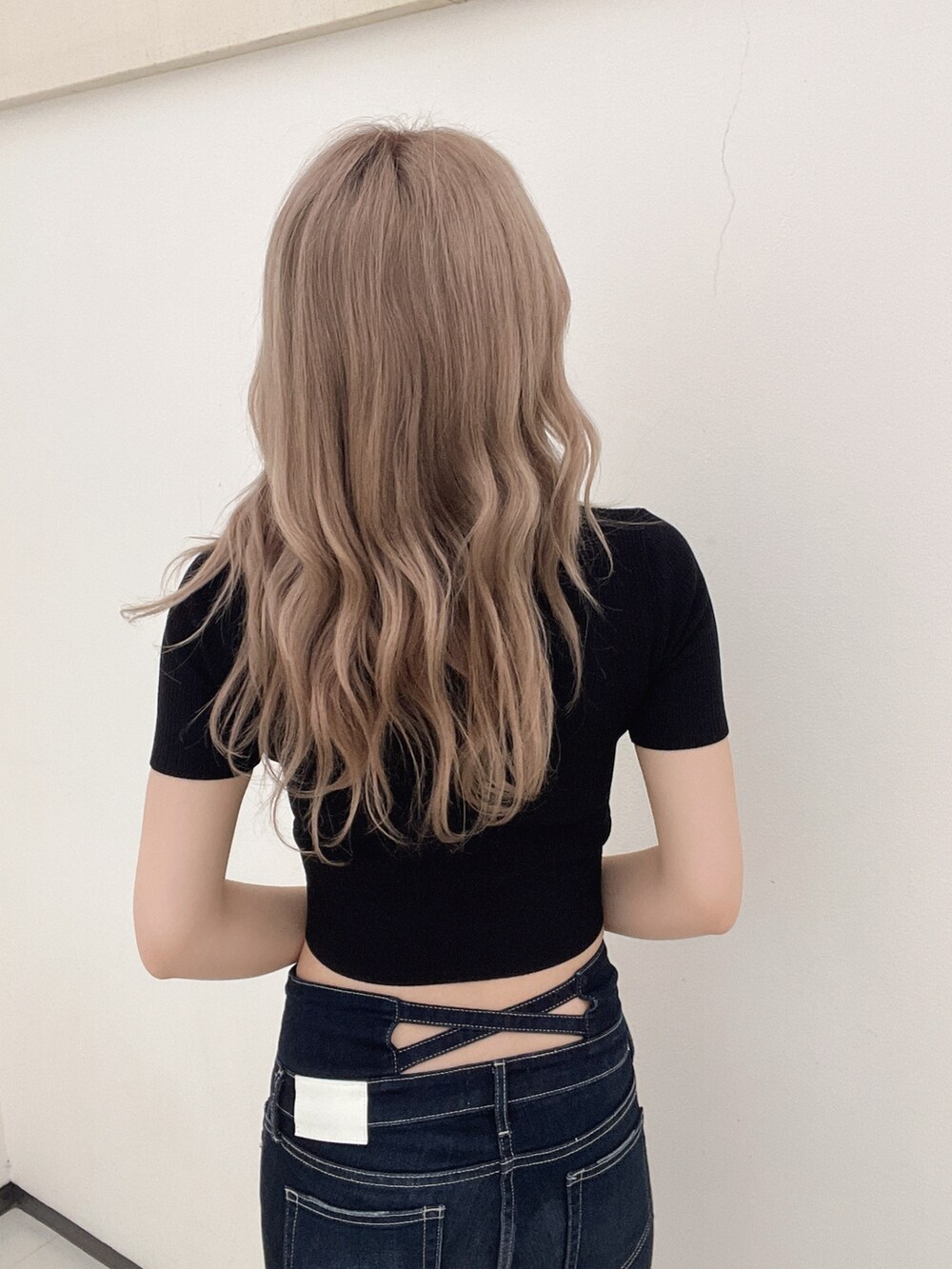 ブラック系のニット/セーター、ブルー系のデニムパンツ、ブラック系のパンプスを着用したレディースの春コーディネートの5枚目の写真