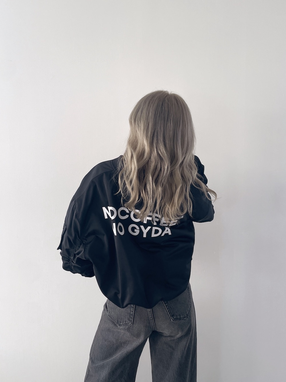 ブラック系のブルゾン、ブラック系のキャミソール、ブラック系のデニムパンツを着用したレディースの秋コーディネートの4枚目の写真