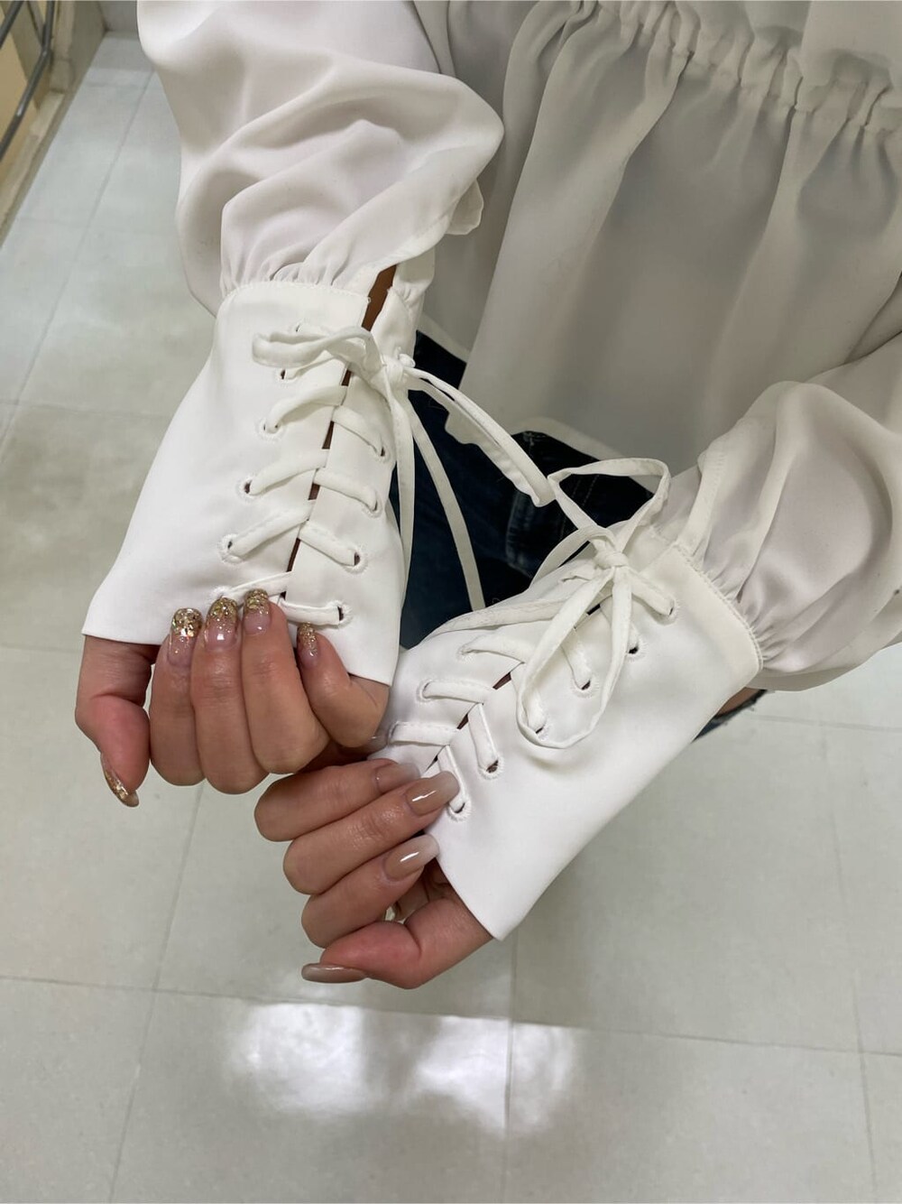 ブラック系のキャミソール、ブラック系のパンプス、ブルー系のデニムパンツを着用したレディースの冬コーディネートの5枚目の写真