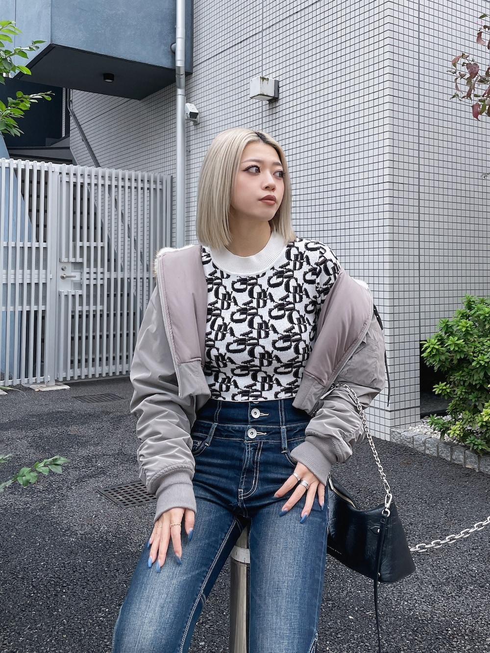 ブルー系のデニムパンツ、グレー系のブルゾン、ホワイト系のニット/セーターを着用したレディースの秋コーディネートの2枚目の写真