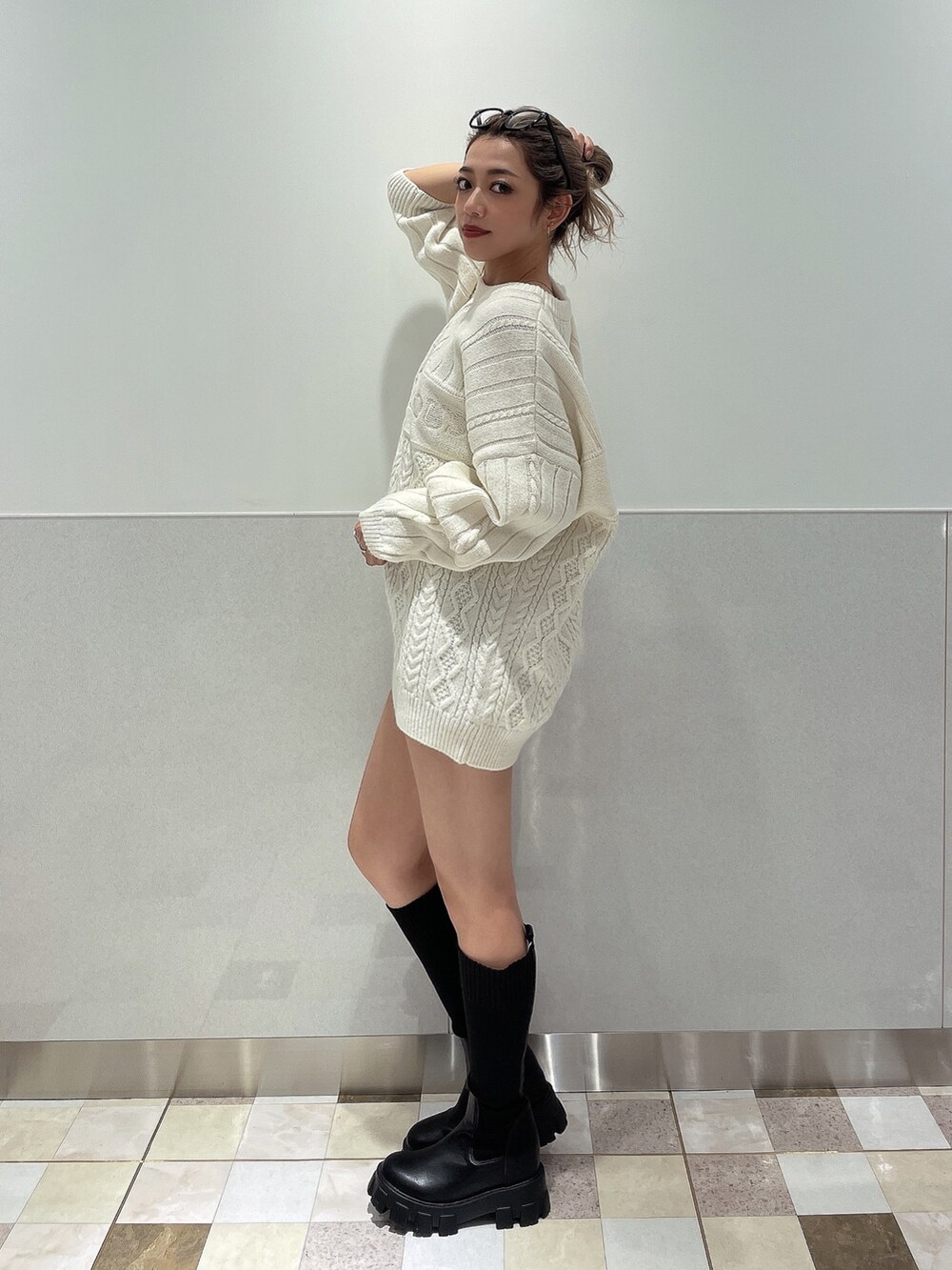 ホワイト系のニット/セーター、ブラック系のブーツを着用したレディースの秋コーディネートの4枚目の写真