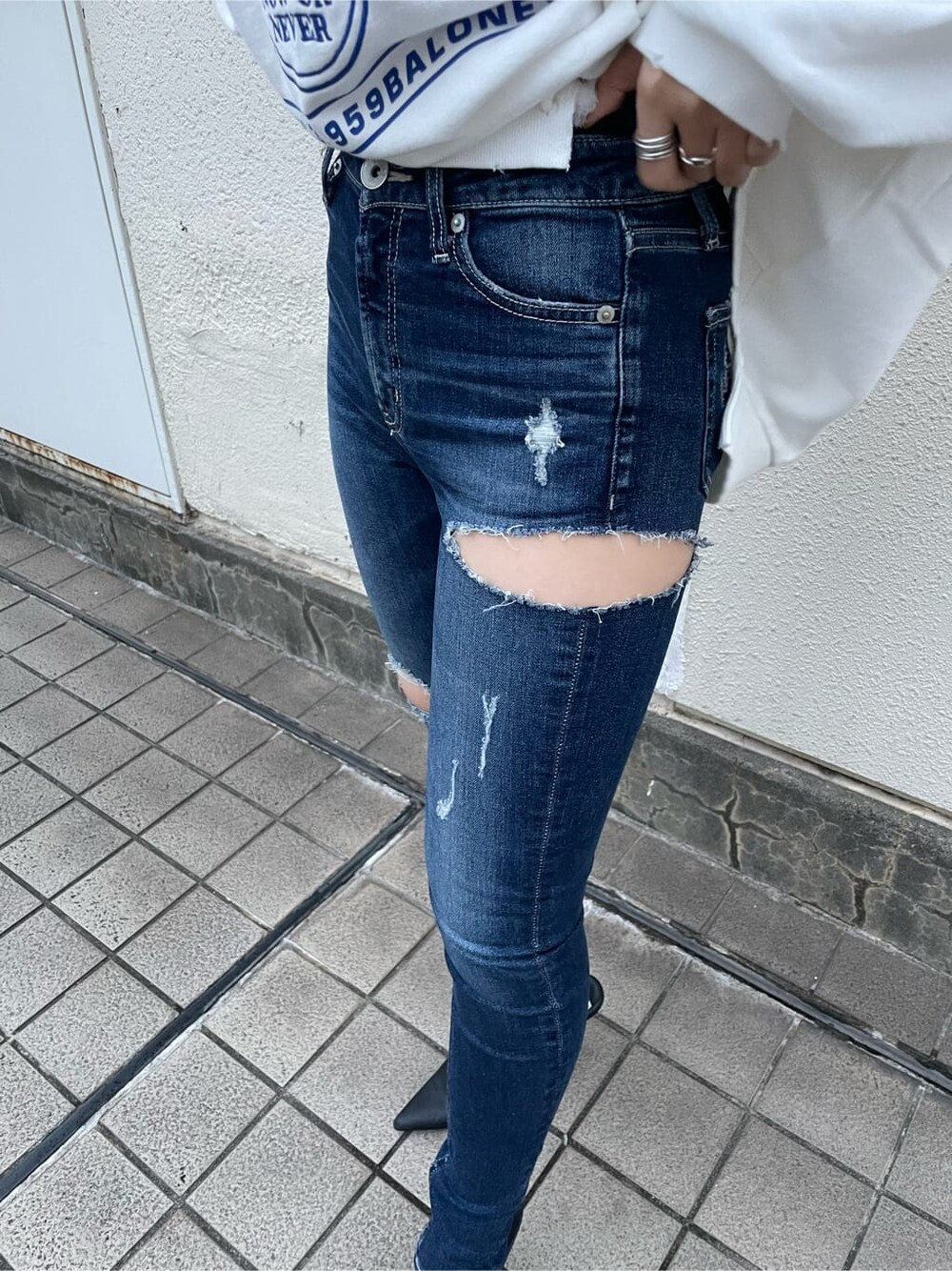 ブルー系のデニムパンツ、ホワイト系のスウェット、ピンク系のスウェットを着用したレディースの秋コーディネートの7枚目の写真