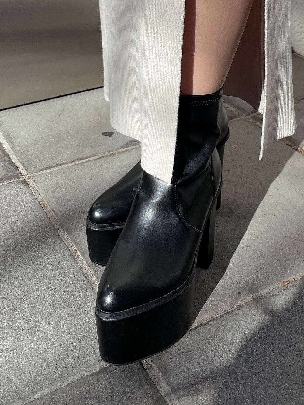 ホワイト系のニット/セーター、ホワイト系のスカート、ブラック系のブーツを着用したレディースの冬コーディネートの7枚目の写真