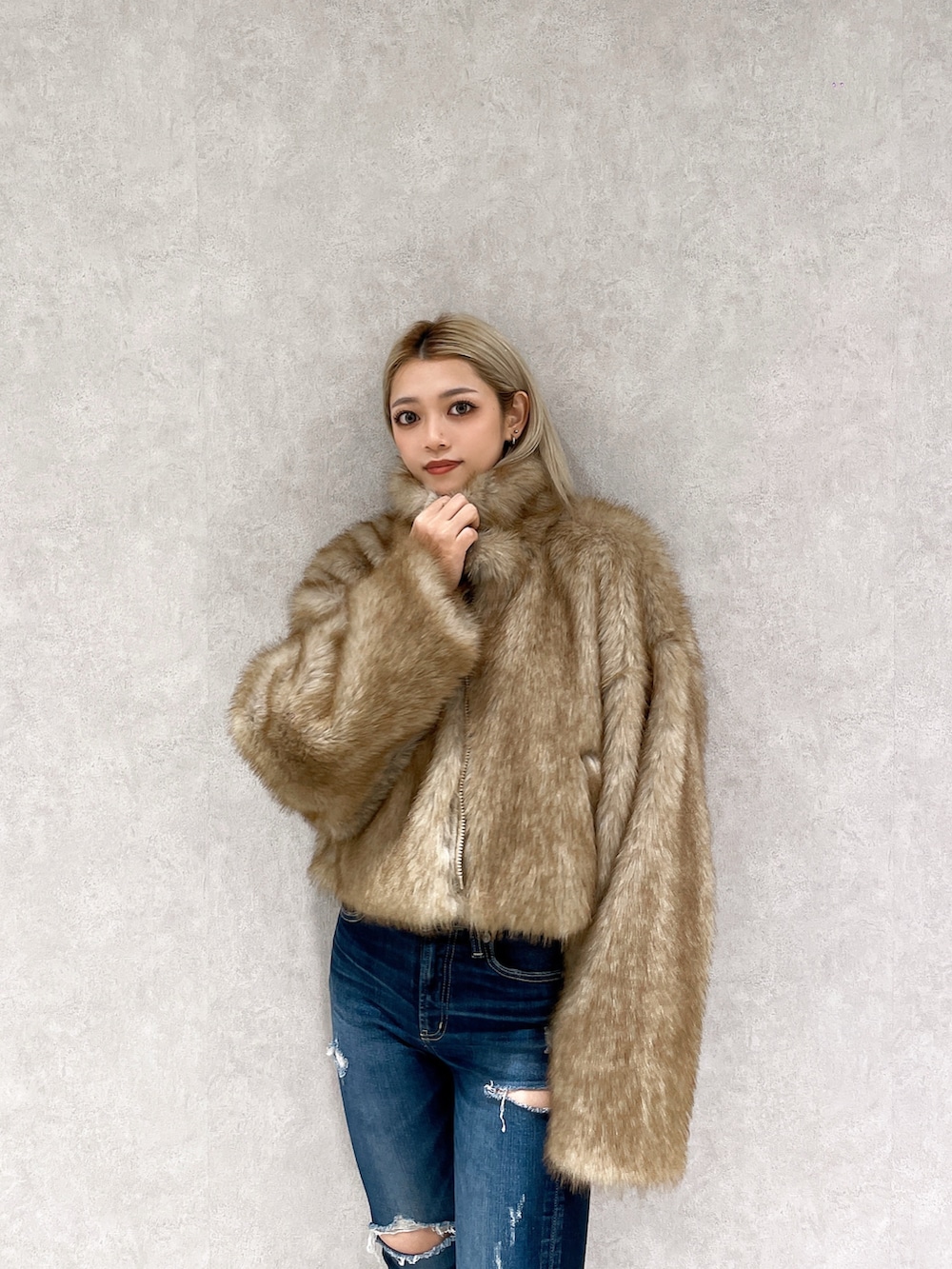 ベージュ系のその他アウター、ホワイト系のニット/セーター、ブルー系のデニムパンツを着用したレディースの冬コーディネートの4枚目の写真