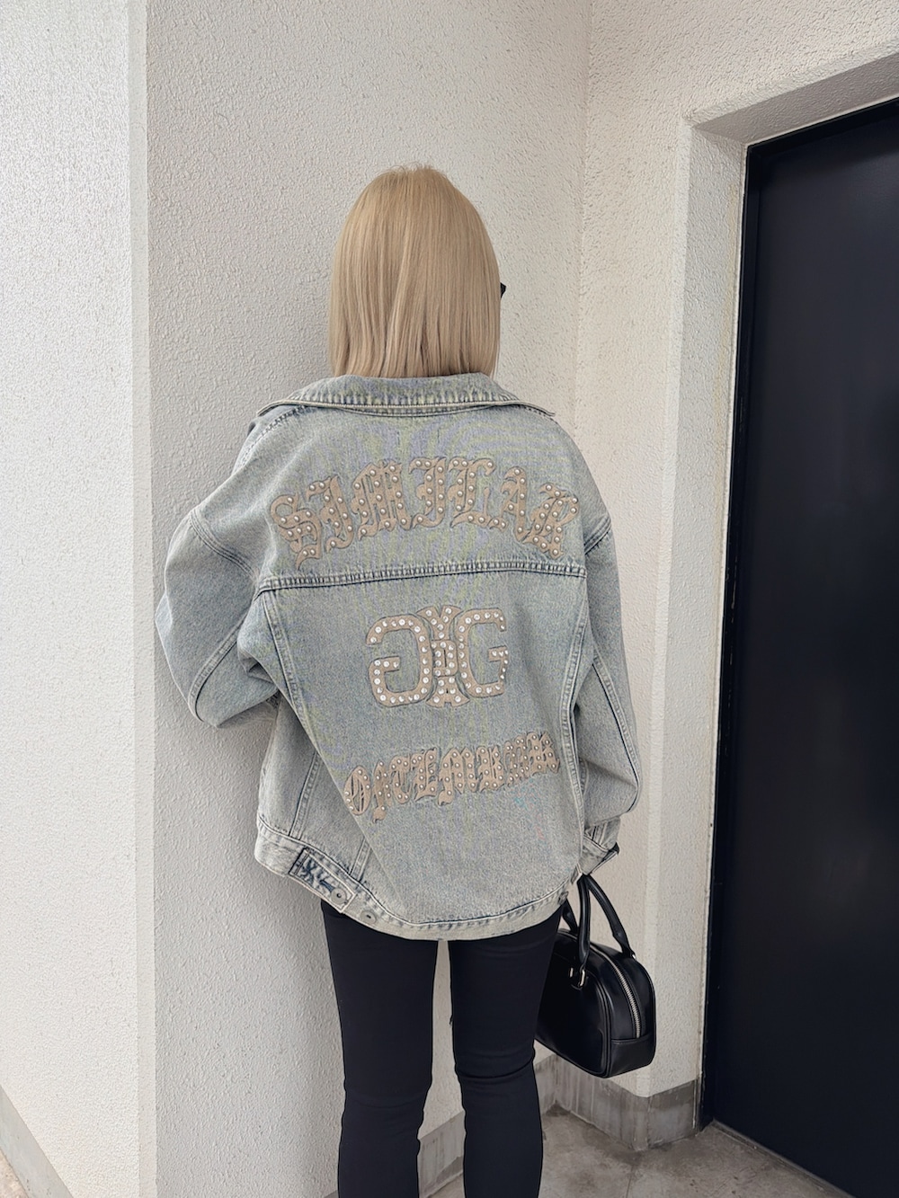 ブルー系のデニムジャケット、その他のニット/セーター、ブラック系のデニムパンツを着用したレディースの春コーディネートの4枚目の写真