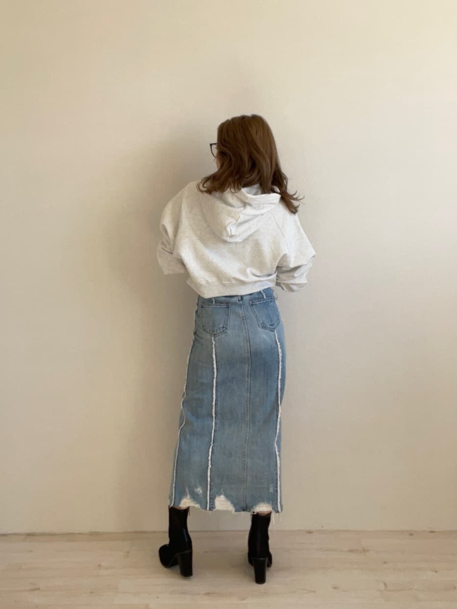 ブラック系のブーツ、グレー系のパーカー、ブルー系のデニムスカートを着用したレディースの冬コーディネートの4枚目の写真