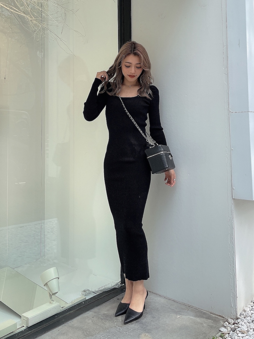 ブラック系のワンピース、ブラック系のハンドバッグ、ブラック系のパンプスを着用したレディースの秋コーディネートの3枚目の写真