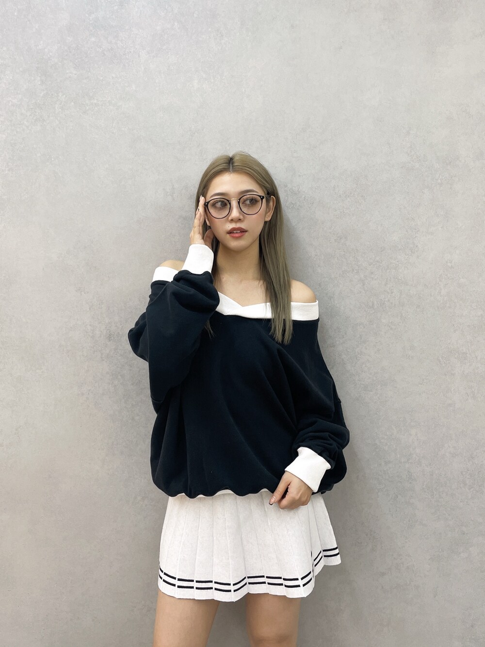 ブラック系のスウェット、ホワイト系のスカート、ブラック系のブーツを着用したレディースの冬コーディネートの2枚目の写真