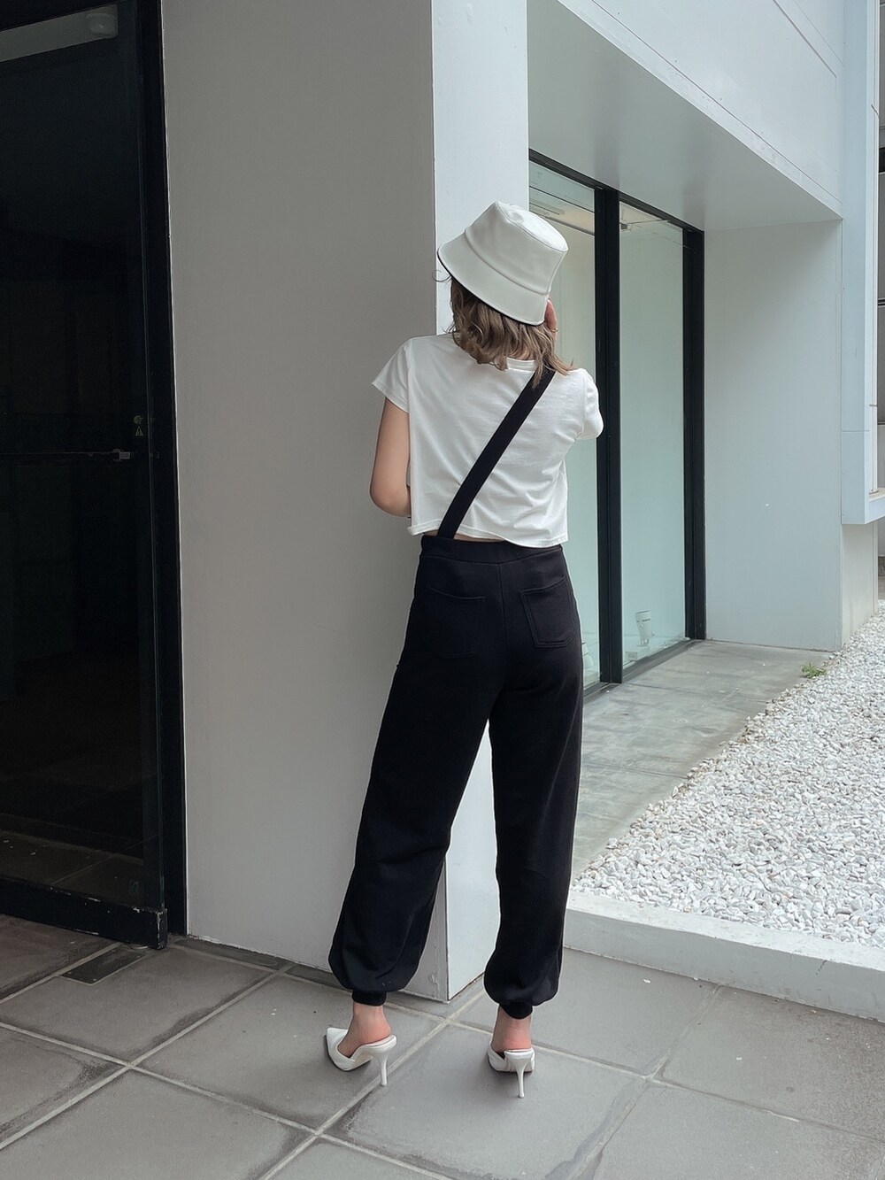ブラック系のつなぎ/オールインワン、ホワイト系のTシャツ/カットソー、ホワイト系のパンプスを着用したレディースの春コーディネートの2枚目の写真