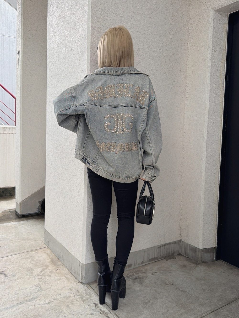 ブルー系のデニムジャケット、その他のニット/セーター、ブラック系のデニムパンツを着用したレディースの春コーディネートの2枚目の写真