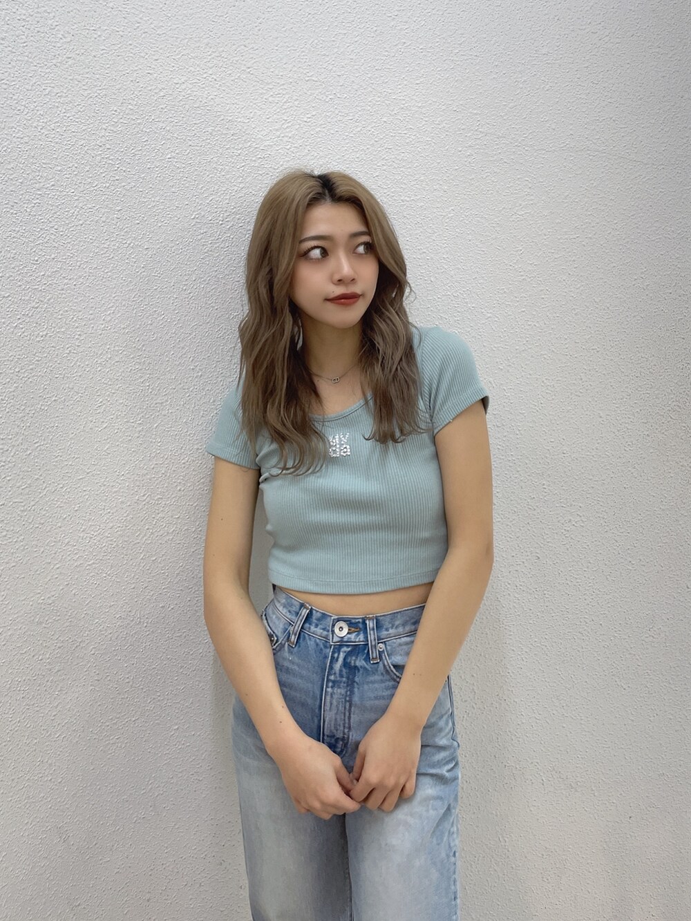 グリーン系のTシャツ/カットソー、ブルー系のデニムパンツ、ホワイト系のスニーカーを着用したレディースの春コーディネートの4枚目の写真