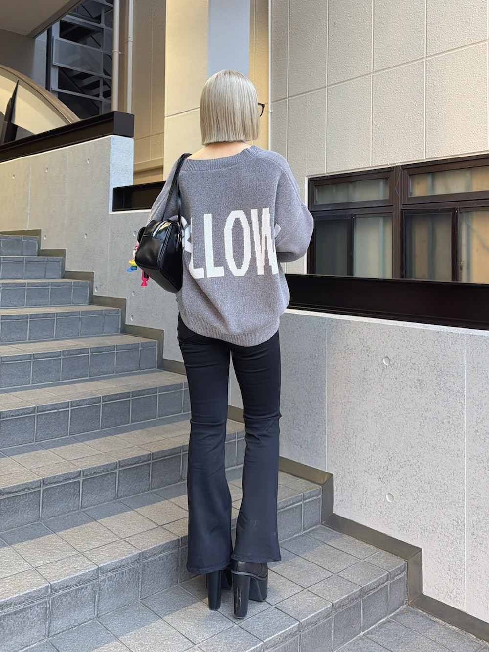 グレー系のカーディガン/ボレロ、ブラック系のデニムパンツ、ブラック系のブーツを着用したレディースの冬コーディネートの2枚目の写真