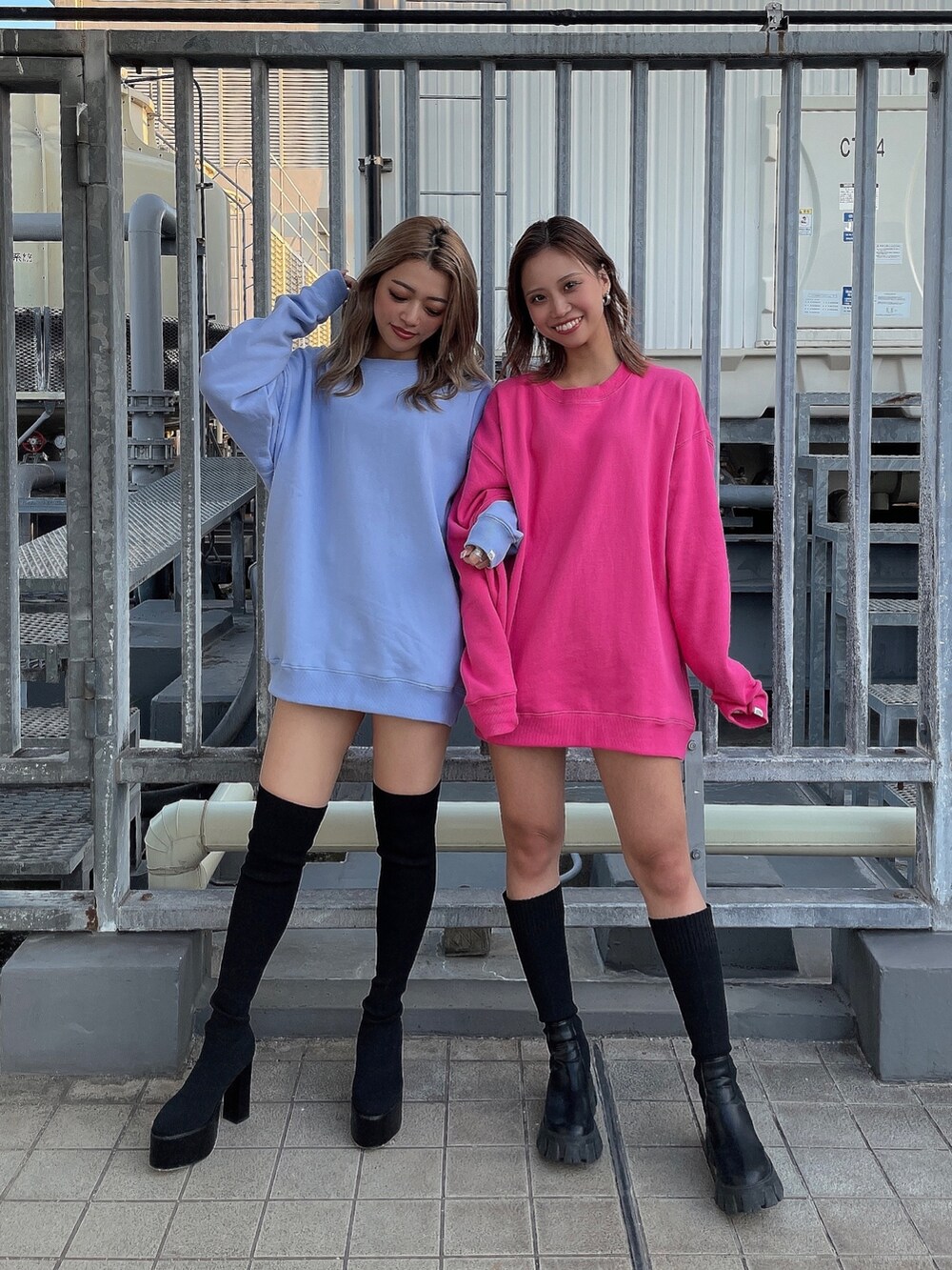 ピンク系のスウェット、ブラック系のブーツ、ブルー系のスウェットを着用したレディースの秋コーディネートの2枚目の写真