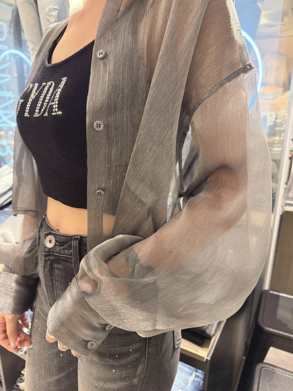 ブラック系のサンダル、グレー系のシャツ/ブラウス、ブラック系のデニムパンツを着用したレディースの夏コーディネートの6枚目の写真
