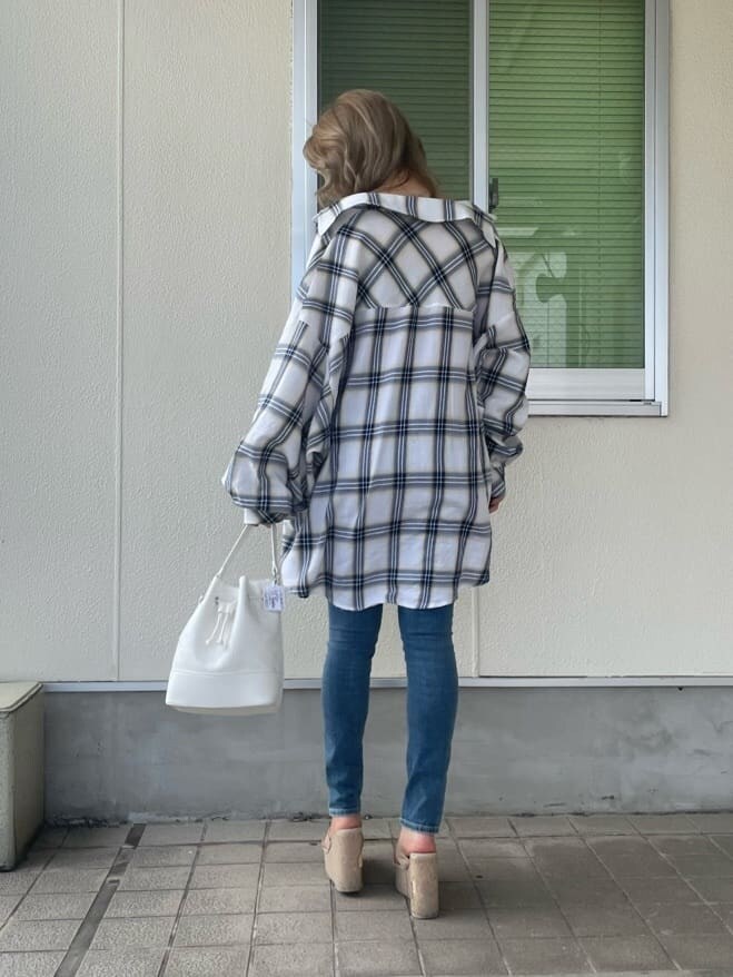 ホワイト系のシャツ/ブラウス、ホワイト系のハンドバッグ、ブルー系のデニムパンツを着用したレディースの夏コーディネートの3枚目の写真