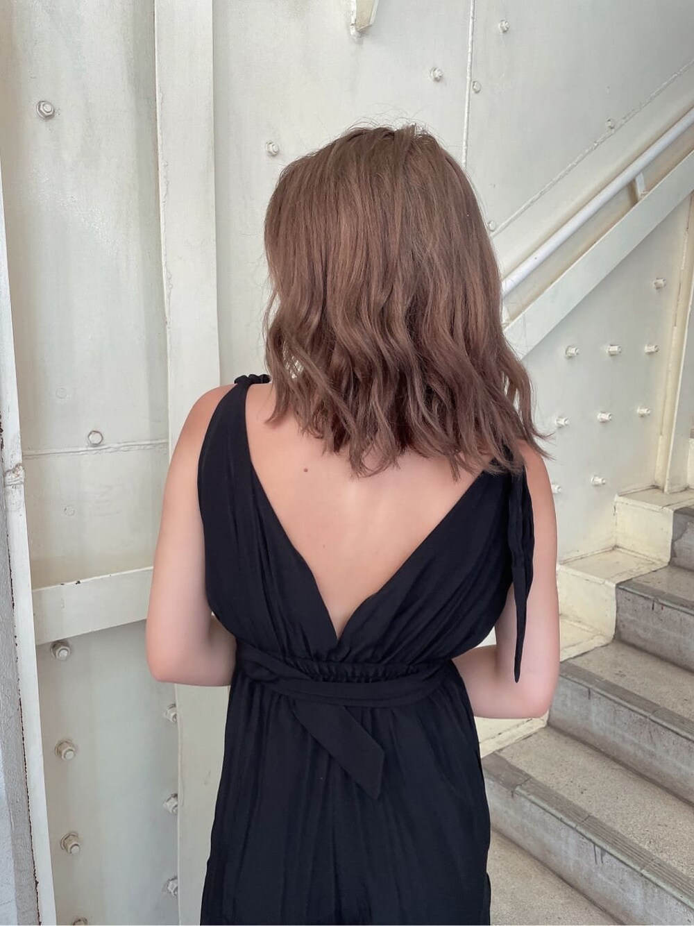 ブラック系のつなぎ/オールインワン、ブラック系のサンダル、ホワイト系のハンドバッグを着用したレディースの夏コーディネートの6枚目の写真