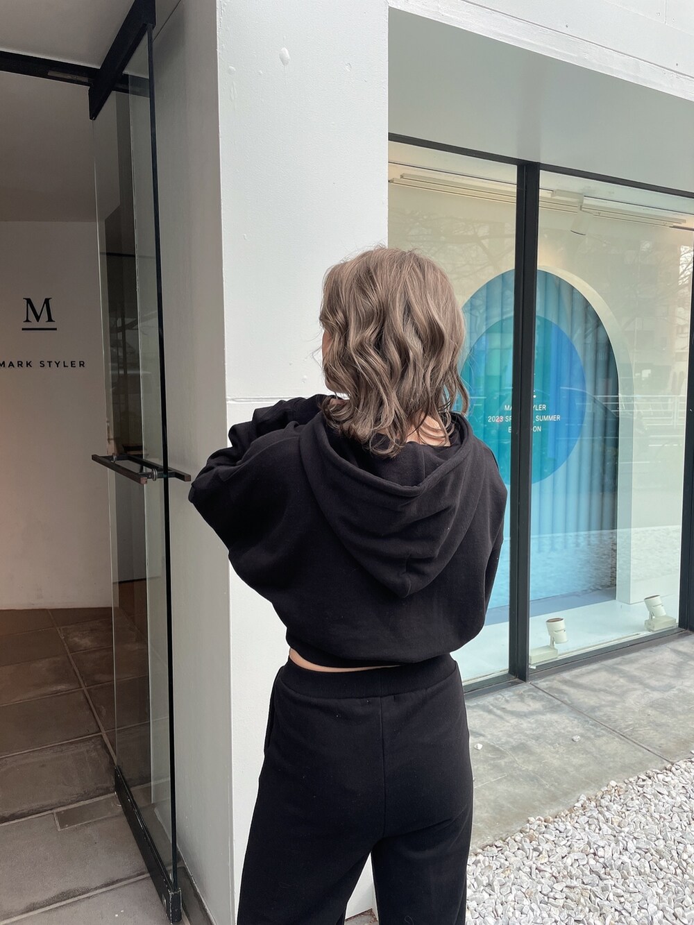 ブラック系のパーカー、ブラック系のスウェットパンツ、ブラック系のスニーカーを着用したレディースの冬コーディネートの5枚目の写真