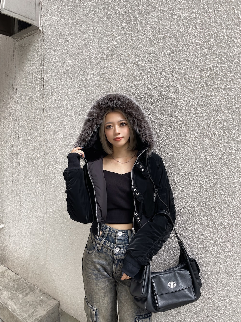 ブラック系のブルゾン、ブラック系のデニムパンツ、ブラック系のブーツを着用したレディースの秋コーディネートの4枚目の写真