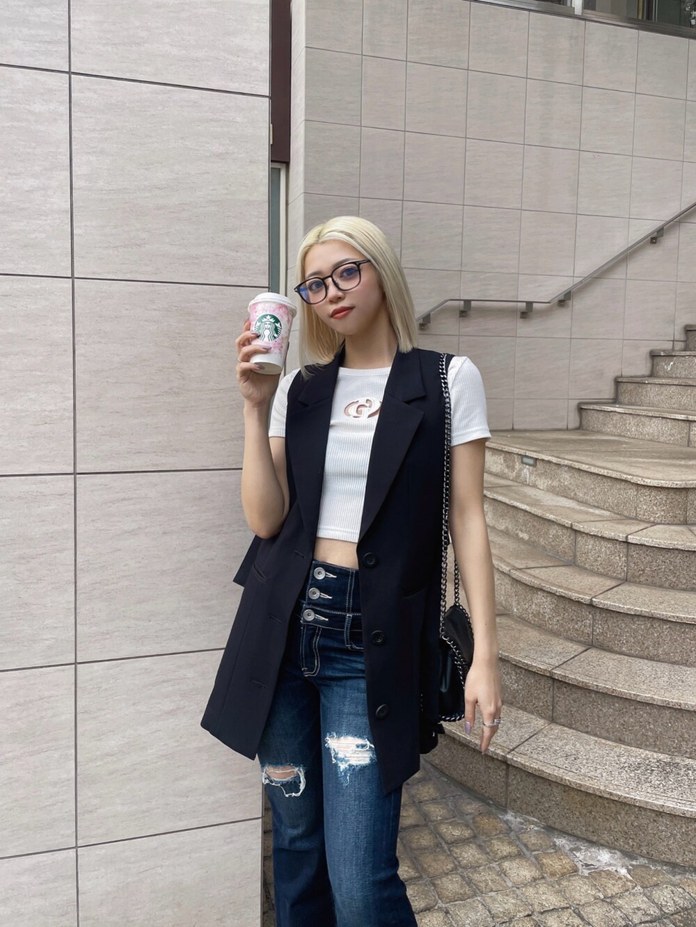 ブラック系のベスト、ホワイト系のTシャツ/カットソー、ブルー系のデニムパンツを着用したレディースの春コーディネートの4枚目の写真